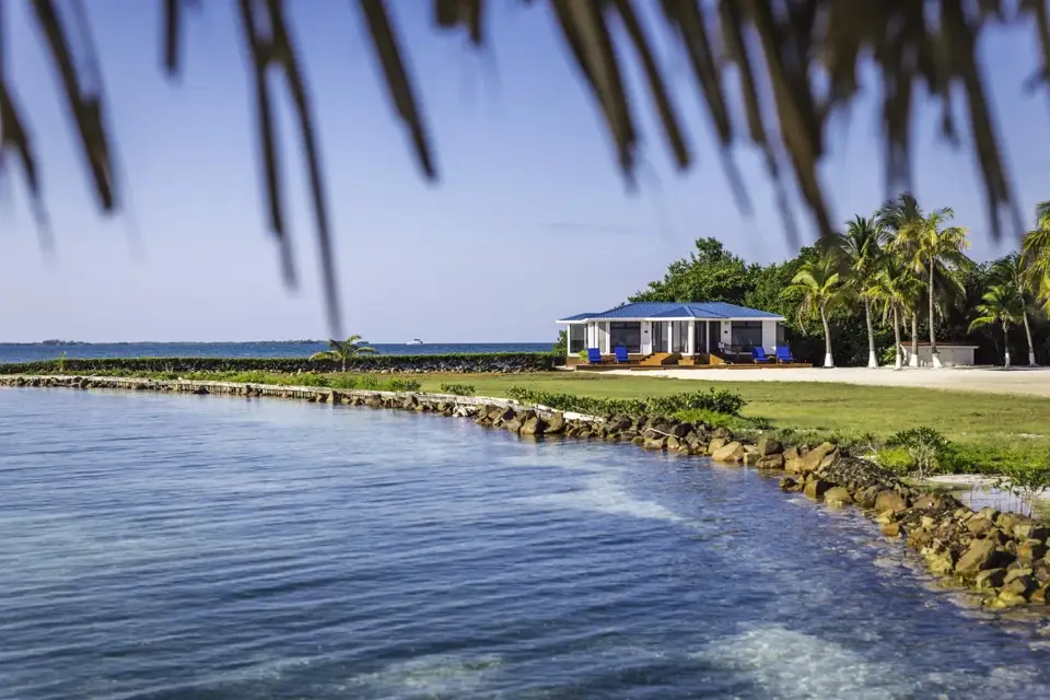 A waterfront residence framed by palms and calm blue water